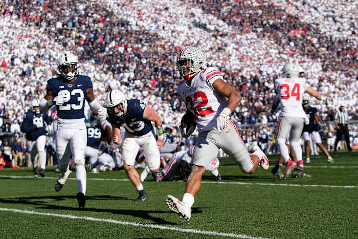 Ohio State Buckeyes running back TreVeyon Henderson (32) runs for a 7-yard touchdown past Penn State Nittany Lions linebacker Tyler Elsdon (43) and linebacker Curtis Jacobs (23) during the fourth quarter